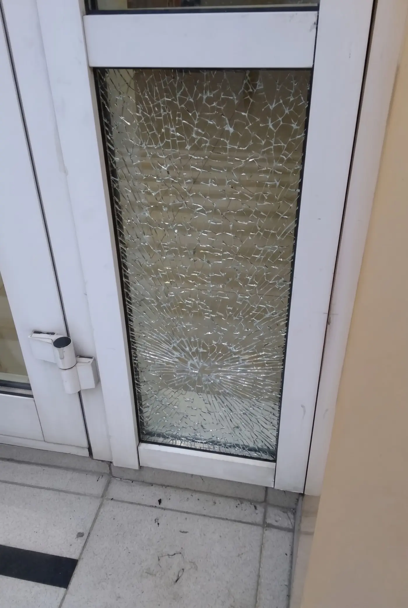 ДО замены: разбитое стекло в двери офиса — паутина трещин, вход закрыт