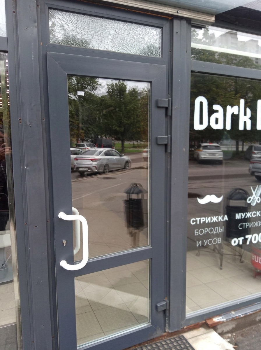 Разбитый верхний стеклопакет входной алюминиевой двери барбершопа Dark в Москве — трещины, паутина сколов